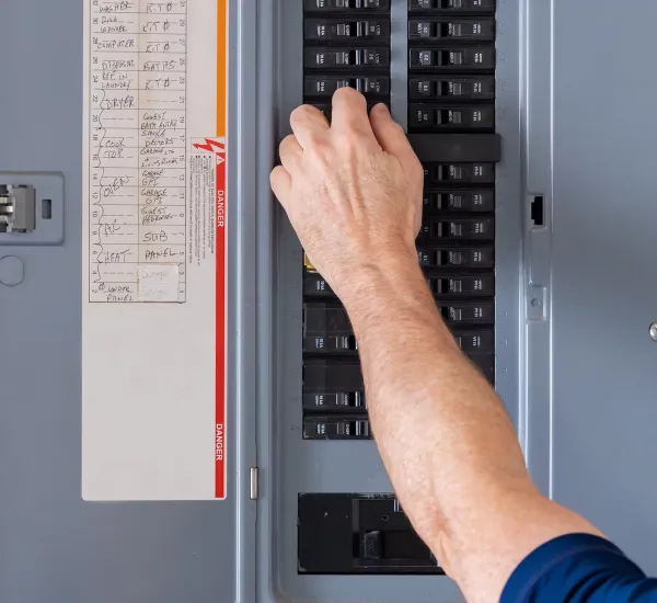 electrician adjusting control panel switches